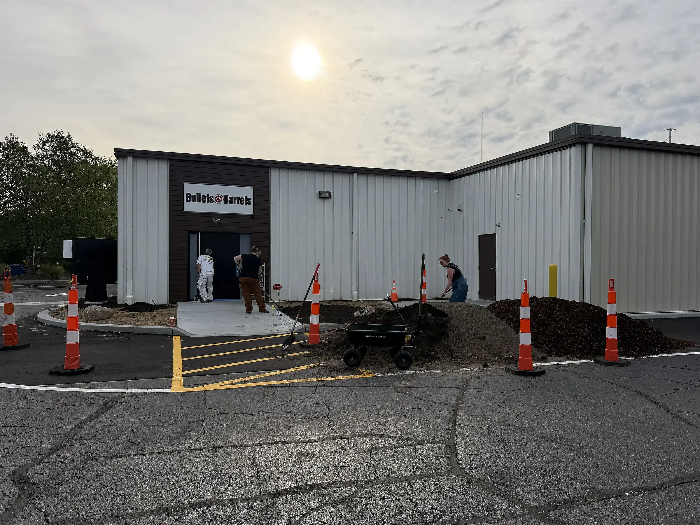 The team planting beds at a commercial building, with traffic cones around the work